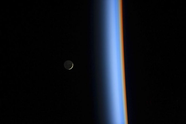 A crescent moon rises over the cusp of the Earth's atmosphere in this picture by Japan Aerospace Exploration Agency astronaut Koichi Wakata onboard the International Space Station taken February 1, 2014. REUTERS/NASA/Handout