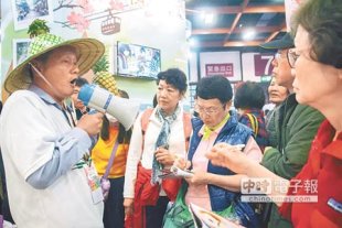高市農業局帶農民參加「台北國際春季旅展」宣傳「一日農夫」遊程，還有參觀民眾拿出筆記本抄重點。（林宏聰攝）