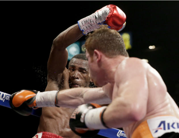 Canelo Alvarez, of Mexico, front, swings at Erislandy Lara, of Cuba during their super welterweight fight, Saturday, July 12, 2014, in Las Vegas. (AP Photo/John Locher)