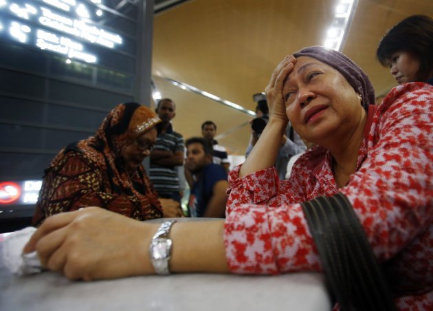 A woman (front), who said she believed her sister was on Malaysia Airlines flight MH-17, cries as she waits for more information about the crashed plane, at Kuala Lumpur International Airport in Sepang, July 18, 2014. The Malaysia Airlines Boeing 777 airliner was brought down over eastern Ukraine on Thursday, killing all 295 people aboard and sharply raising the stakes in a conflict between Kiev and pro-Moscow rebels in which Russia and the West back opposing sides. REUTERS/Samsul Said (MALAYSIA - Tags: TRANSPORT DISASTER CIVIL UNREST POLITICS)