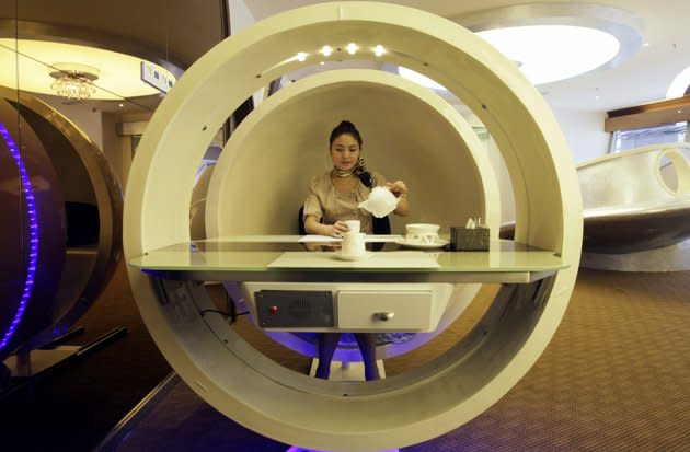 Une serveuse pose à l'intérieur d'une cabine "salle à manger", en forme d'oeuf, dans un restaurant qui a pour thème l'A380. Ce restaurant situé à Chongqing en Chine, se nomme