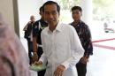 Jakarta governor and president-elect Widodo smiles as   he arrives for work at city hall in Jakarta