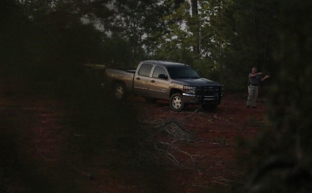 Investigador é visto no local onde foram encontrados corpos. (Foto: AP)
