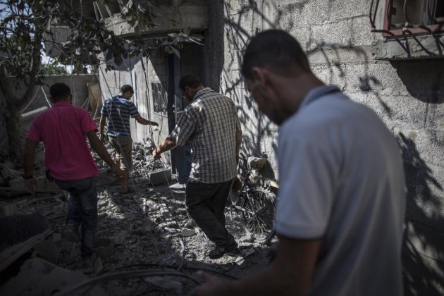 Palestinians walk amidst debris in the Bureij refugee camp in the central Gaza Strip, on August 1, 2014