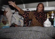 A family member of a pregnant woman who was stoned to death by her own family wails over her dead body in an ambulance at a local hospital in Lahore, Pakistan, Tuesday, May 27, 2014. Nearly 20 members of the woman's family, including her father and brothers, attacked her and her husband with batons and bricks in broad daylight before a crowd of onlookers in front of the high court of Lahore, police investigator Rana Mujahid said. (AP Photo/K.M. Chaudary)