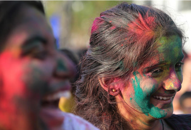 Indian nationals with colored powder on their faces celebrate the Holi festival in suburban Pasay, south of Manila, Philippines, Sunday March 16, 2014. The event is led by Indian nationals as they mar