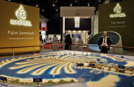 FILE - In this file photo taken Monday Oct. 5, 2009, a visitor looks at the Palm Jumeirah model at the Nakheel stand at the Cityscape exhibition in Dubai, United Arab Emirates. Dubai's developer Nakheel behind the famed man-made palm-shaped islands said Wednesday, Aug. 20, 2014, that it is repaying 7.9 billion dirhams, or roughly $2.15 billion this month - nearly four years before the last installment is due. (AP Photo/Kamran Jebreili, File)