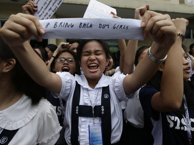 Students from St. Scholastica's College chant slogans and display placards during a protest outside their campus Friday, June 27, 2014 in Manila, Philippines. Thousands of Filipino students from the Roman Catholic-run school for girl joined Friday a global campaign to free more than 200 schoolgirls abducted by Islamic extremists in Nigeria, chanting "bring them back" and urging motorists in the Philippine capital to honk their car horns in solidarity. (AP Photo/Bullit Marquez)