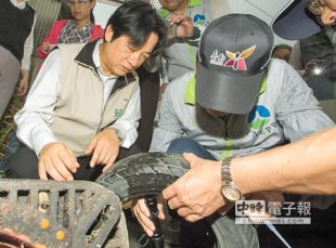 台南市長賴清德（左）到安南區登進行革熱稽察，檢視廢棄輪胎有無病媒蚊孳生。（黃仲裕攝）