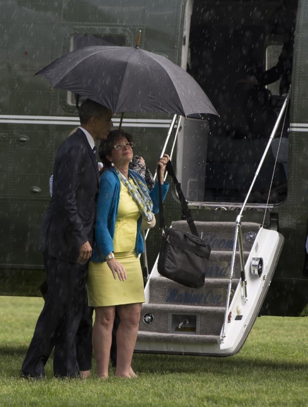 Obama comparte la sombrilla con su asesora Valerie Jarrett. (AP Photo/Carolyn Kaster)