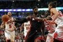 El astro olímpico LeBron James, de Miami Heat, enfrenta la marca de varios jugadores de los Bulls en partido de la NBA, el 9 de marzo de 2014, en Chicago