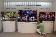A journalist takes pictures of a LG Electronics' Ultra Organic Light-emitting Diode (OLED) 3D TV during a press unveiling in Seoul, South Korea. Monday, Aug. 25, 2014. LG Electronics Inc. is sticking with its strategy of using the exceptionally expensive OLED display technology for TVs, announcing two new giant models with ultra-high definition screens. (AP Photo/Ahn Young-joon)