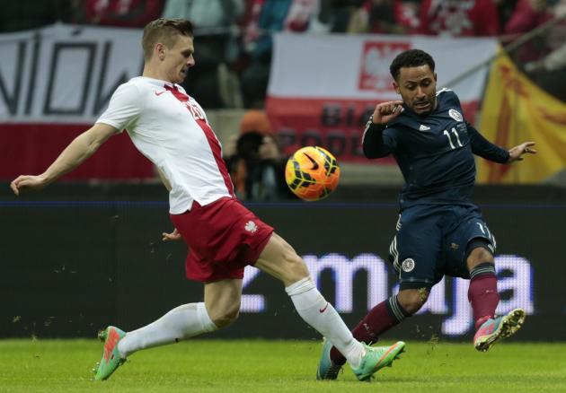 Poland's Lukasz Piszczek and Ikechi Anya of Scotland fight for the ball during their international friendly soccer match in Warsaw