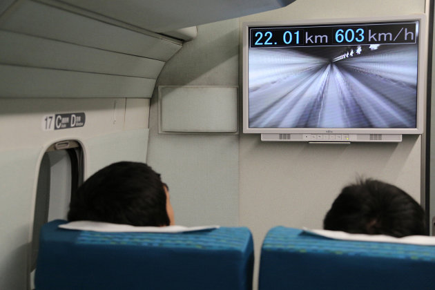 Unos pasajeros del tren de levitación magnética de Central Japan Railway miran un monitor que marca el récord de velocidad de 603 km/h durante una prueba cerca del monte Fuji el 21 de abril de 2015 (Central Japan Railways/AFP | Jiji Press)