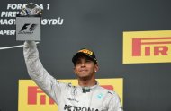 Mercedes' British driver Lewis Hamilton celebrates on the podium after the Hungarian Formula One Grand Prix at the Hungaroring circuit in Budapest on July 27, 2014