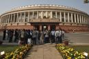 People stand in front of the Indian parliament building on the opening day of the winter session in New Delhi