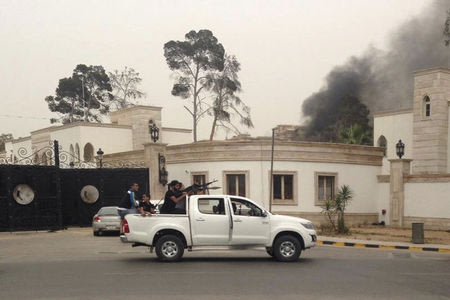 Armed men aim their weapons from a vehicle as smoke rises in the background near the General National Congress in Tripoli May 18, 2014. REUTERS/Stringer