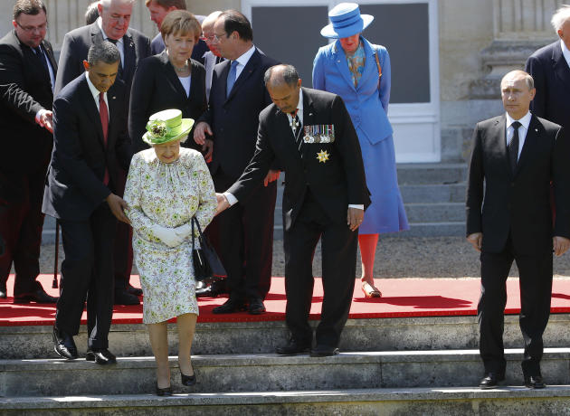 Russian President Vladimir Putin stands at right as U.S. President Barack Obama, left, and New Zealand's Governor-General Jerry Mateparae guide Britain's Queen Elizabeth II to her position for a group