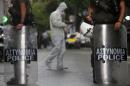 Special Police unit secures an area as a police   investigator searches for clues following a shoot-out in central Athens