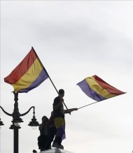 Un hombre sostiene banderas republicanas durante la concentración que ha tenido lugar en la Puerta del Sol de Madrid después de conocerse la abdicación del Rey en favor del príncipe Felipe. EFE