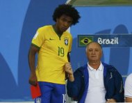 Brazil's coach Luiz Felipe Scolari tugs on Willian's jersey during their 2014 World Cup semi-finals against Germany at the Mineirao stadium in Belo Horizonte July 8, 2014. REUTERS/Ruben Sprich