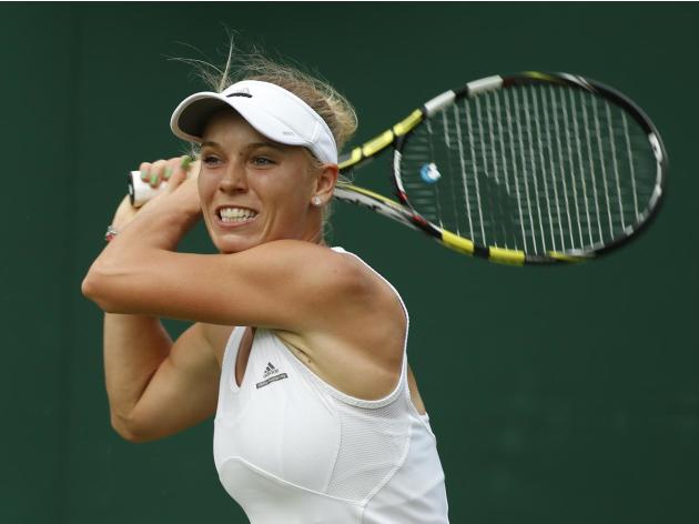 La tenista danesa Caroline Wozniacki realiza un tiro en el torneo de Wimbledon el 23 de junio de 2014. (AP Photo/Alastair Grant, File)