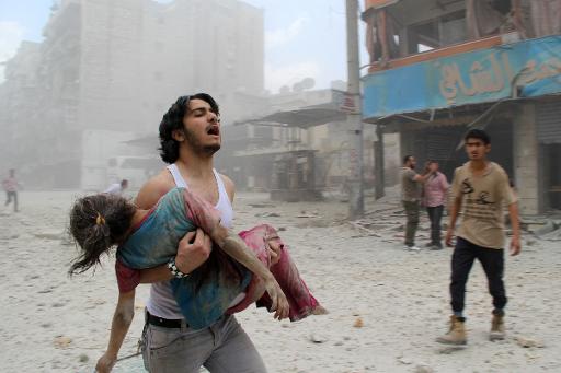 A man carries a young girl who was injured in a reported barrel-bomb attack by government forces on June 3, 2014 in Kallaseh district in the northern city of Aleppo