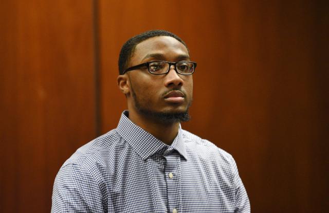 Khalil Wheeler-Weaver, 23, who is charged in the deaths of three women in 2016, stands as the jury enters the court room in Essex County Superior Court.