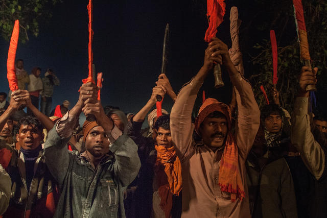 BARIYARPUR, NEPAL - NOVEMBER 28: A group of devotees elevate as a blessing their traditional kukri knifes before the beginning of the animal sacrifices during the celebration of the Gadhimai festival on November 28, 2014 in Bariyarpur, Nepal. Over two million people attended this year's Gadhimai festival in Nepal's Bara Disctrict. Held every five years at the Gadhimai temple of Bariyarpur, the festival is the world's largest slaughter of animals, during which between thousands of water buffaloes, pigs, goats, chickens, rats and pigeons are slaughtered in order to please Gadhimai, the Goddess of Power. (Photo by Omar Havana/Getty Images)