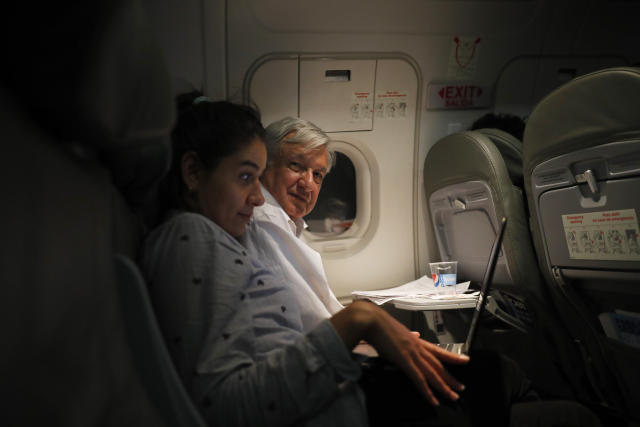 Mexican President Andres Manuel Lopez Obrador sits next to an assistant as he travels in economy class aboard a commercial flight from Guadalajara to Mexico City, on Saturday, March 9, 2019. Lopez Obrador has answered more questions from the press, flown in more economy-class flights, posed for more selfies with admiring citizens and visited more genuinely risky areas with little or no security than several combined decades of his predecessors. (AP Photo/Marco Ugarte)
