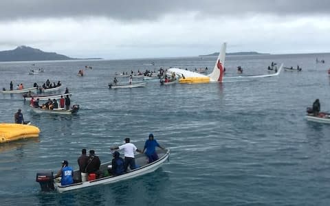 People are evacuated from an Air Niugini plane crashed in the waters in Wen - Credit: James Yaingeluo/Reuters