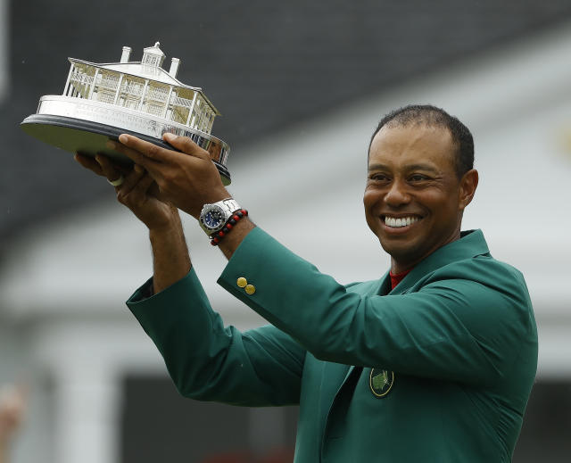 Tiger Woods wears his green jacket holding the winning trophy after the final round for the Masters golf tournament Sunday, April 14, 2019, in Augusta, Ga. (AP Photo/Matt Slocum)